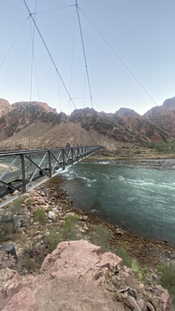 Backpackers cross the bridge over the Colorado River