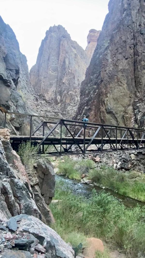 Chris runs across a bridge that spans the Bright Angel Creek