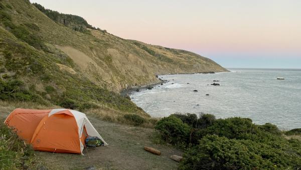 A tent perched on a seaside bluff