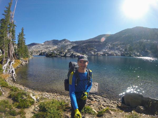 Chris in front of a clear mountain lake